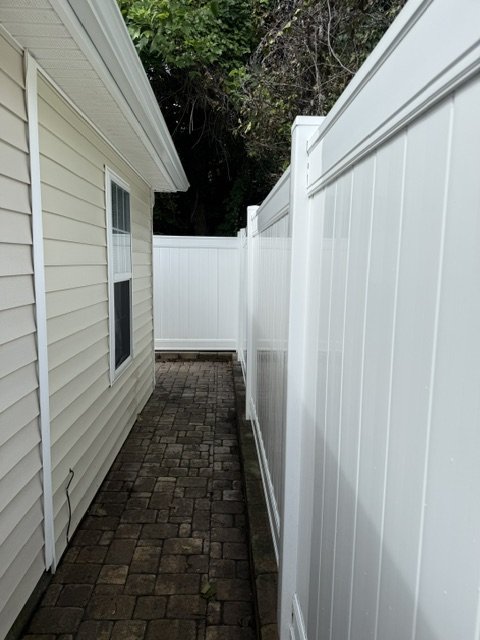 Fence after — full length + gate, clean, brick pavers dry