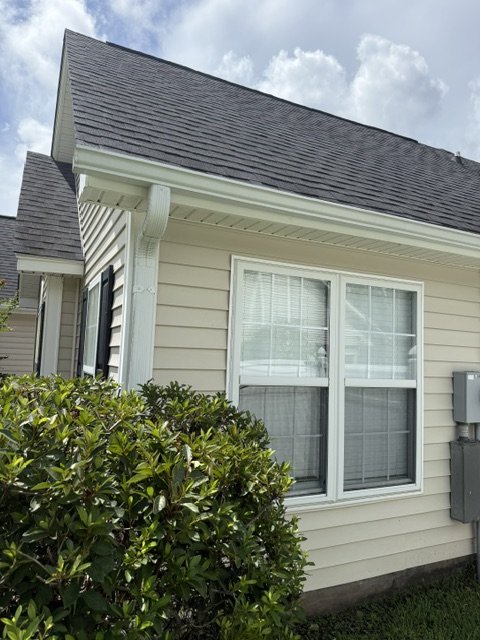 House after — cream siding restored, fence line clean